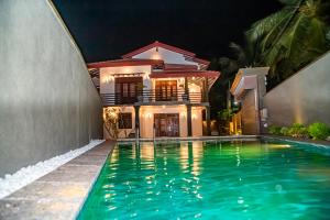 a house with a swimming pool at night at Chala Villa in Ambalangoda