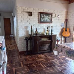 um quarto com uma parede de tijolos e um piso de madeira em Guesthouse Playa Chinchorro em Arica