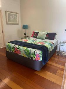 a bedroom with a bed with a colorful comforter at Charming Queeenslander in City Centre in Cairns