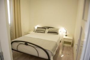a bedroom with a bed with two pillows on it at Apartments by the sea Milna, Vis - 8895 in Rukavac