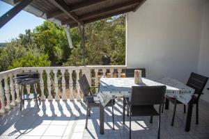 a patio with a table and chairs on a balcony at Apartments by the sea Milna, Vis - 8895 in Rukavac