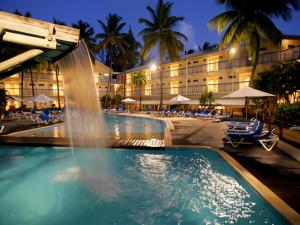 una piscina in un resort con cascata di Agréable studio avec terrasse et vue sur la Marina a Les Trois-Îlets