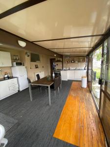 a living room with a table and a kitchen at Young Hostel in Rotorua