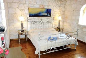 Agios LeonにあるIra Agios Leon Zakynthosのベッドルーム1室(ベッド1台、テーブル2台、ランプ2つ付)