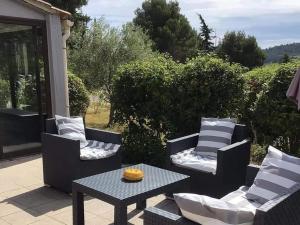 un patio con 2 sedie e un tavolo con di Charming holiday home with private pool a Montbrun-des-Corbières