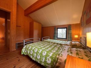 1 dormitorio con 1 cama con edredón verde en Beautiful holiday home in Hastière with garden, en Blaimont