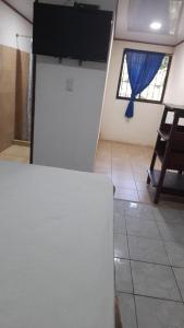 um quarto com uma mesa e uma televisão na parede em Hospedaje Angela em Península de Nicoya