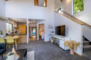 a living room with a couch and a tv and a kitchen at Little Black Chalet Methven in Methven