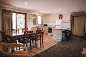 eine Küche und ein Esszimmer mit einem Tisch und Stühlen in der Unterkunft Riverbush Cottages in Monash