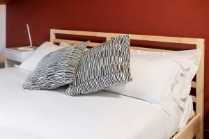 uma cama com duas almofadas pretas e brancas em Charming 2.5Room Flat in Center of Monforte d'Alba em Monforte dʼAlba