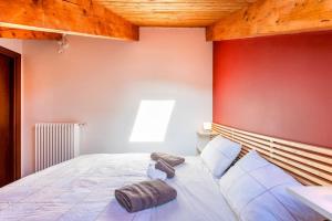 um quarto com uma cama grande e uma parede vermelha em Charming 2.5Room Flat in Center of Monforte d'Alba em Monforte dʼAlba