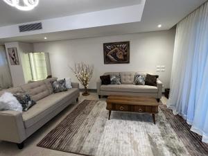 ein Wohnzimmer mit 2 Sofas und einem Couchtisch in der Unterkunft Lovely Apartment New giza in Abū Rawwāsh