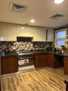 a kitchen with wooden cabinets and a stove top oven at Lovely Apartment New giza in Abū Rawwāsh