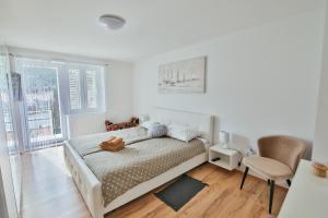 a white bedroom with a bed and a chair at Seaside holiday house Luka, Dugi otok - 20212 in Sali