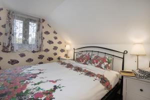 1 Schlafzimmer mit einem Bett mit Blumenbettdecke in der Unterkunft Family friendly house with a parking space Vranov Dol, Prigorje - 20590 in Jastrebarsko