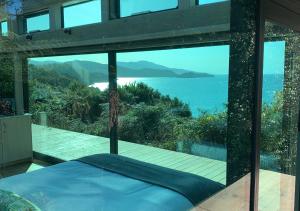 a bedroom with a view of the ocean at Hananui PurePod in Stewart Island