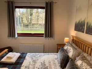 a bedroom with a bed in front of a window at River house in Birnam