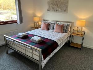 a bedroom with a bed with pillows on it at River house in Birnam