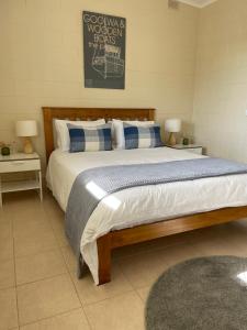Un dormitorio con una cama grande con almohadas azules y blancas. en Hideaway Tom’s on Mundoo Channel - Waterfront, en Hindmarsh Island