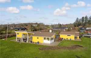 ein kleines gelbes Haus auf einem Grasfeld in der Unterkunft Beautiful Home In Spttrup With Kitchen in Lihme