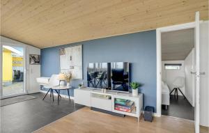 ein Wohnzimmer mit blauen Wänden sowie einem Tisch und Stühlen in der Unterkunft Beautiful Home In Spttrup With Kitchen in Lihme