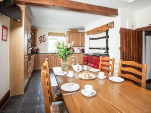 a kitchen with a wooden table and a dining room at Brookbank Farm in Jodrell Bank