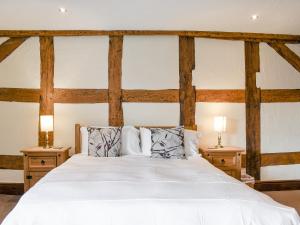 a bedroom with a white bed with two night stands at Brookbank Farm in Jodrell Bank
