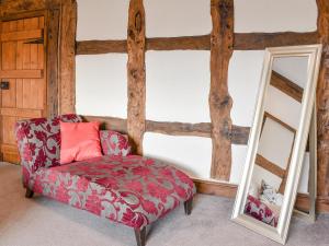 a living room with a red chair and a mirror at Brookbank Farm in Jodrell Bank +20 photos