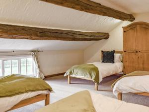 a bedroom with two beds and a window at Brookbank Farm in Jodrell Bank