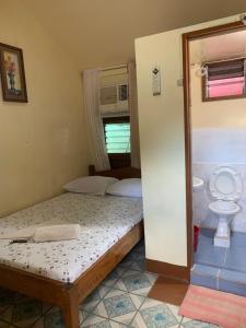 a small bedroom with two beds and a toilet at Blessed Inn in San Miguel