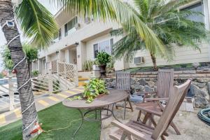 a patio with a table and chairs and a palm tree at Unit 8 Maui Ohana Modern Studio in Wailuku