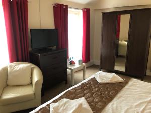 a bedroom with a bed and a chair and a mirror at The Lethbridge Arms in Taunton