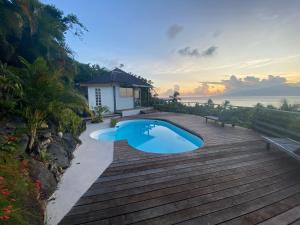 a swimming pool on a deck next to a house at Moorea Happy Bungalow in Teavaro