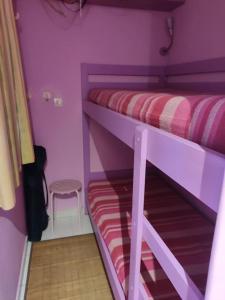 um quarto roxo com um beliche e um banco em Super-cute colourful, cozy flat em Saint-Raphaël