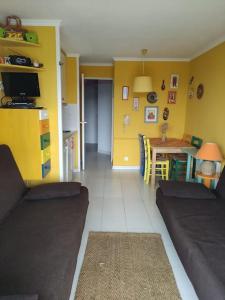 uma sala de estar com um sofá e uma sala de jantar em Super-cute colourful, cozy flat em Saint-Raphaël