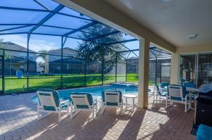 a patio with chairs and a table and a swimming pool at Olivia's Dream Villa on WindsorHills in Orlando