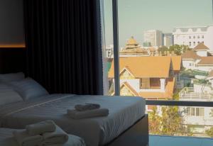 - une chambre avec 2 serviettes sur un lit et une fenêtre dans l'établissement LILLY HOTEL, à Xã Thang Tam