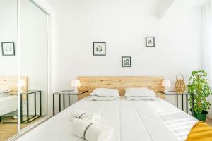 a white bedroom with a large bed and mirrors at Two bedroom apartment close to train station by Lisbon with Sintra in Queluz