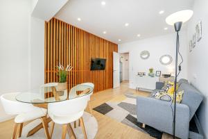 a living room with a glass table and a couch at Two bedroom apartment close to train station by Lisbon with Sintra in Queluz