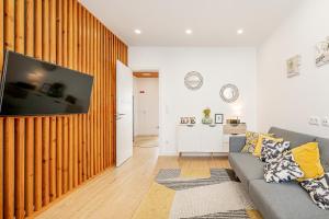 a living room with a couch and a flat screen tv at Two bedroom apartment close to train station by Lisbon with Sintra in Queluz