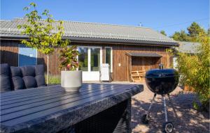 a grill sitting on a wooden table in a yard at 2 Bedroom Awesome Apartment In Sveio in Sveio
