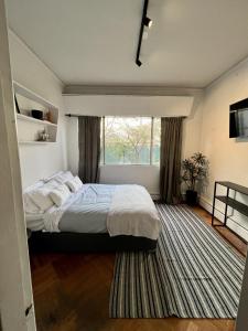 Un dormitorio con una cama grande y una ventana en ¡Espectacular casa en pleno Barrio Italia!, en Santiago