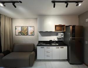 uma pequena cozinha com um sofá e um frigorífico em Apartamento luxuoso a poucos metros da praia em Salvador