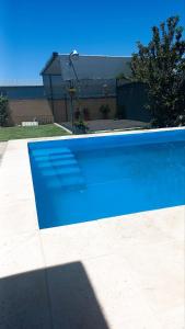 una piscina azul frente a una casa en La casa de Beatriz Paz, confort y tranquilidad en San Rafael
