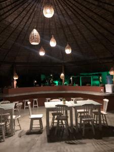 a dining room with tables and chairs and lights at Resort Pipa Casa20 - Triplex maravilhoso in Pipa +12 photos