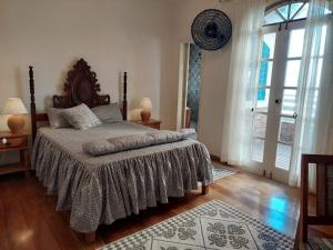 a bedroom with a bed and a large window at Casa de Praia Alameda Azul in Guarapari