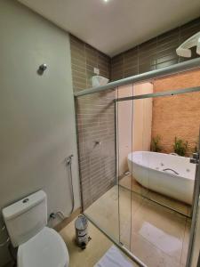 a bathroom with a toilet and a bath tub at Pousada Paraiso in Alto Paraíso de Goiás