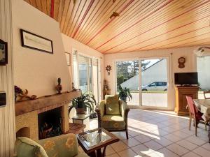 uma sala de estar com lareira e tecto em madeira em Maison Jullouville, 4 pièces, 8 personnes - FR-1-361-95 em Jullouville-les-Pins