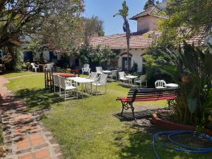 a group of chairs and tables in a yard at la posada del sol in Villa Gesell