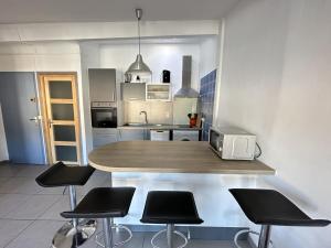 eine Küche mit einem Tisch mit Stühlen und einer Mikrowelle in der Unterkunft Appartement Port-Vendres, 2 pièces, 4 personnes - FR-1-309-216 in Port-Vendres